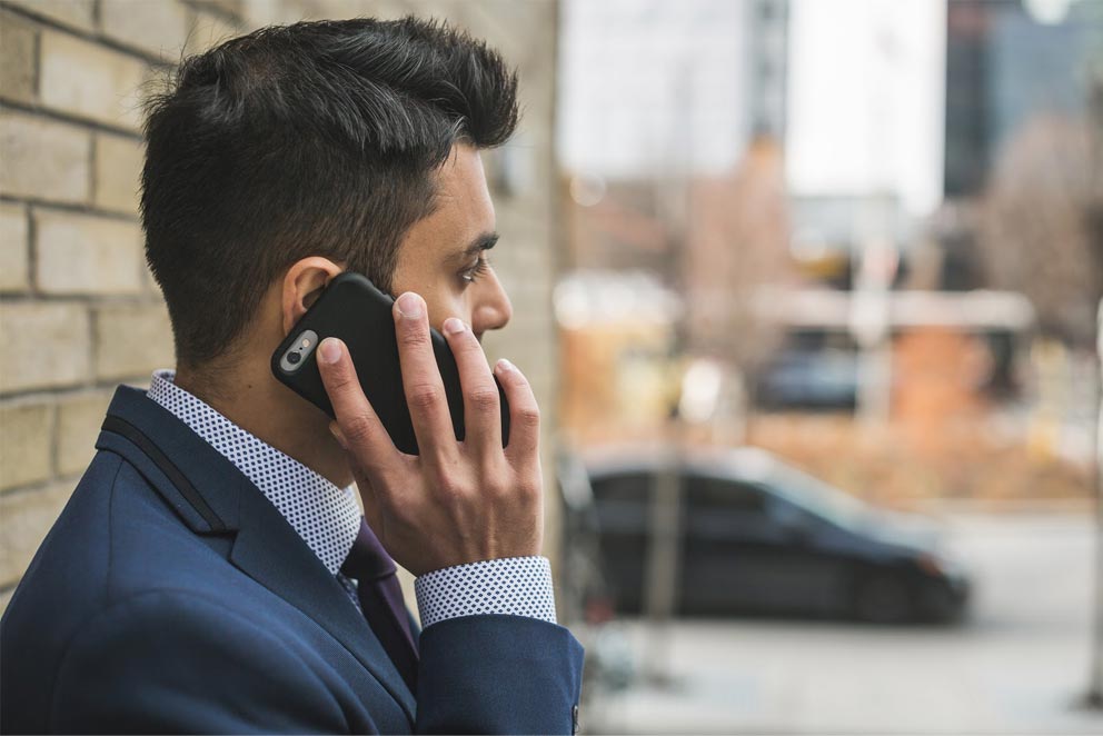 A photo of a man talking to someone over the phone.